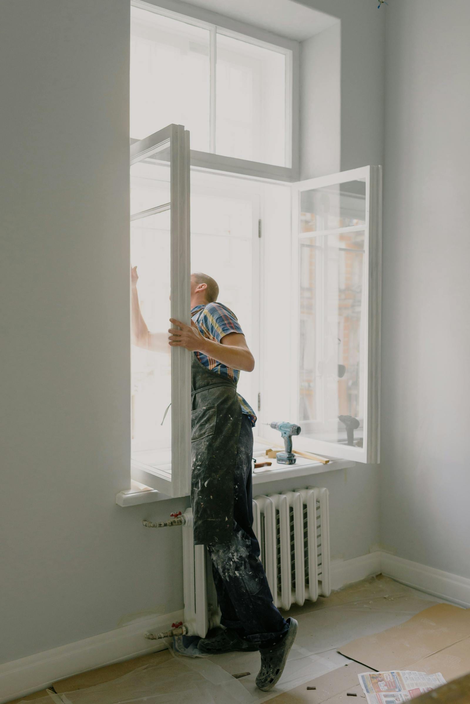 Pose d'un nouveau châssis bois par un artisan, en rénovation